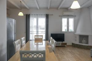 a living room with a table and chairs and a television at Villa & Suite Elia Mykonos in Mikonos