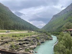 a river in the middle of a valley with mountains at City Tour in Polisi i Vogël