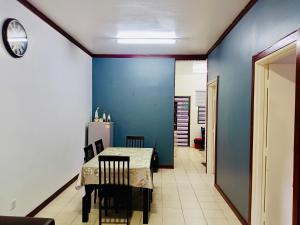 a dining room with a table and a blue wall at Golden Bright Future Trading in Tanah Rata