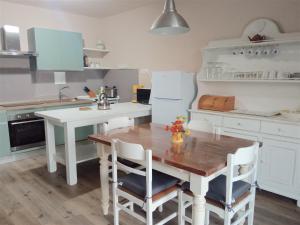 a kitchen with a wooden table and a white refrigerator at La Solaria in Carmignano