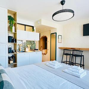 1 dormitorio con 1 cama con 2 sillas y cocina en L’émeraude - Superbe studio tout équipé + parking, en Metz