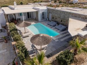an aerial view of a house with a swimming pool and umbrellas at Villa & Suite Elia Mykonos in Mikonos