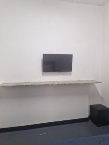 a flat screen tv on a white wall at Chacara cad club quarto de casal in Sao Jose do Rio Preto +9 photos
