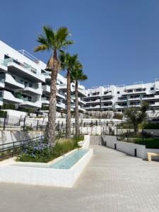 un gran edificio de apartamentos con palmeras y una piscina en Xava Dreams Aire, en Villacosta