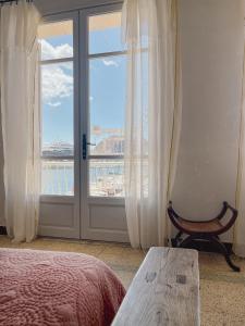 een slaapkamer met een bed en een raam met uitzicht bij CASA ABEILLE in La Ciotat