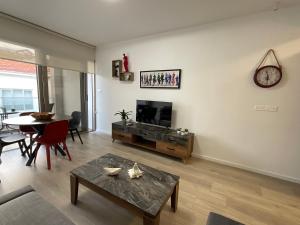 a living room with a table and a tv at Le Voyageur II in Larnaca
