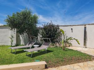 莱切Dimora Bianca 64的两把椅子坐在院子里的草地上