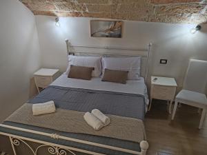 莱切Dimora Bianca 64的卧室里有一张床，床上放着两条毛巾。