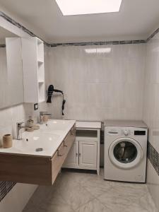 莱切Dimora Bianca 64的带水槽和洗衣机的浴室