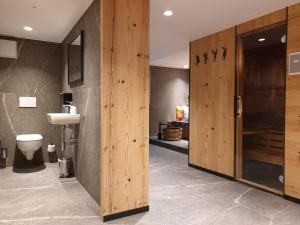 een badkamer met een toilet en een houten deur bij Haus Bergrausch in Krün +49 foto's