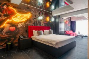a bedroom with a bed and a wall covered in graffiti at SO City Hotel Adults Only in St. Julianʼs