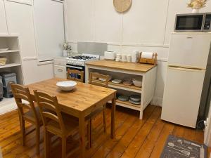 a kitchen with a wooden table and a refrigerator at Canterbury Cottage - dog friendly - fully fenced in Wonthaggi