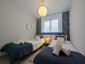 Un dormitorio con dos camas y una ventana. en Xava Dreams Aire, en Villacosta