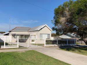 a white fence in front of a white house at Canterbury Cottage - dog friendly - fully fenced in Wonthaggi