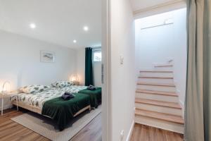 a bedroom with a bed with a green blanket at Grande maison & annexe, à deux pas de la Rochelle in Nieul-sur-Mer