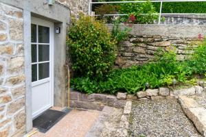 an entrance to a stone building with a white door at Nature et Repos in Corrèze +17 photos