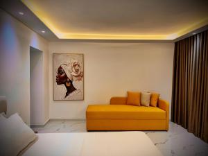 a living room with a yellow couch and a painting at Dine Hotel in Ksamil