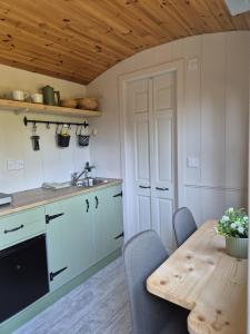 a kitchen with a table and chairs and a sink at Clissmann Farm Shepherds Hut in Rathdrum