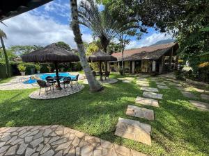 a backyard with a table and chairs and a pool at Toca do Camarão in São Sebastião