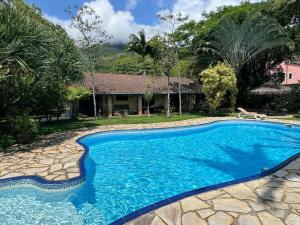 a swimming pool in front of a house at Toca do Camarão in São Sebastião