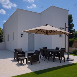 Una mesa y sillas bajo una sombrilla en un patio. en Villa il Fagiano, en Nardò