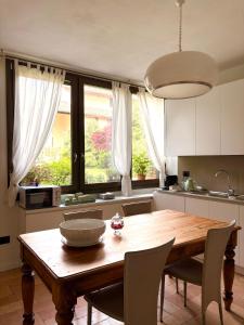 a kitchen with a wooden table with chairs and a bowl on it at Maison Jardin in Ostiano