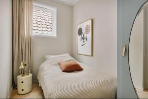 a small bedroom with a bed and a mirror at Central apartment with 2 bedrooms in Bergen