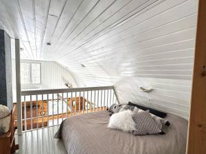 a bedroom with a bed and a white wall at Villa Lempeänranta in Pello