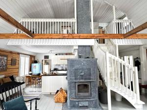 a living room with a fireplace and a staircase at Villa Lempeänranta in Pello