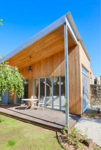 ein Haus mit einer Holzterrasse mit einem Tisch in der Unterkunft Le Loft du Pré - Maison d'architecte - Le Mans in Le Mans