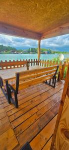 una panchina di legno su una terrazza con vista sull'acqua di River house Una a Kravlja