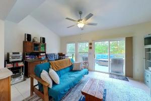 a living room with a blue couch and a ceiling fan at Townhomes of Providence --- 9 John Hall Dr in Ocean View