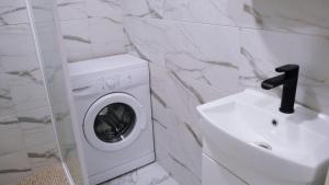 a washing machine and a sink in a bathroom at A cosy apartment near the border in Narva
