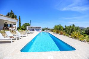 una piscina con sedie e una villa di Private Oasis in Algarve with Pool & Fruit Garden a Loulé Altre 58 foto