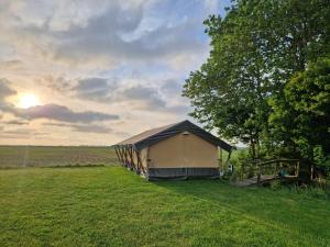 欣德洛彭Glamping Safaritent 4 persoons的田野中间的帐篷