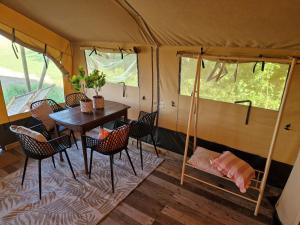 欣德洛彭Glamping Safaritent 4 persoons的帐篷内的用餐室,配有桌椅