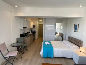 a bedroom with a bed and a table and a kitchen at Le Voyageur II in Larnaca