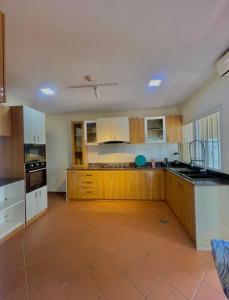 una grande cucina con armadi in legno e pavimento piastrellato di Vanity Villa Luxe Residence Ikoyi a Lagos