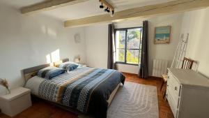 a bedroom with a bed and a window at Au puits de Figa in Figanières +7 photos