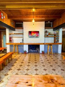 ein großes Wohnzimmer mit einem Kamin und einem Tisch in der Unterkunft Hostel Bucalemu in San Martín de los Andes