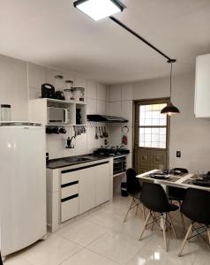 a kitchen with a white refrigerator and a table with chairs at Flat Duplex - Flat & Residence Premium in Campo Grande
