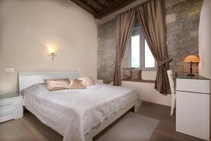 a bedroom with a white bed and a window at Desiderata Studio Apartment in Split