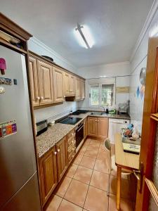 a kitchen with wooden cabinets and a stainless steel refrigerator at Casa Claudia in Calpe +3 photos