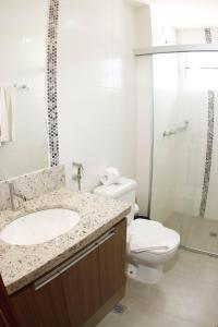 a bathroom with a toilet and a sink and a shower at Hotel Marina - OFICIAL in Caldas Novas