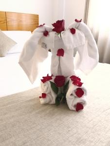 a couple of stuffed animals on a bed with roses at Fenix Machupicchu in Machu Picchu