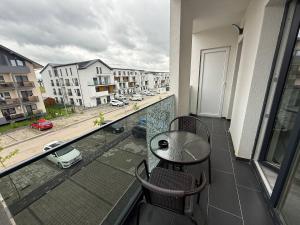 a balcony with a table and chairs and a view of a city at Serenity retreats VRT in Şelimbăr