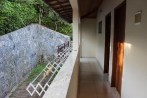 a hallway of a house with a stone wall at Apartamento em João Fernandes - Búzios in Búzios