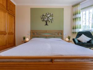 a bedroom with a large bed and a chair at Holiday Home Villa Luz del Sol by Interhome in L'Ametlla de Mar