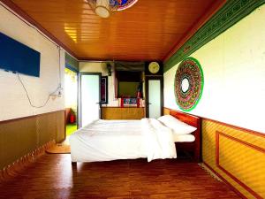 Un dormitorio con una cama y un reloj en la pared. en Homestay Hồ Đá A Căng Tả Phìn, en Sa Pa