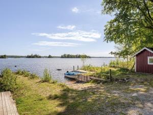 a boat is docked at a dock on a lake at Holiday Home Skärvudde Villan by Interhome in Kalvsvik